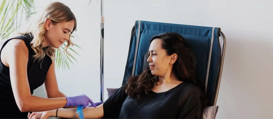 A patient relaxing in a recliner during an IV vitamin drip at The Koa Clinic
